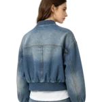 Cropped women's denim bomber jacket rib-knit texture denim fabric and zip macro close-up