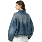 Oversized women's frayed hem denim jacket raw edge detail washed fabric and seam macro close-up