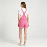 Short women's dungaree overalls denim texture strap buckle and metal hardware macro close-up