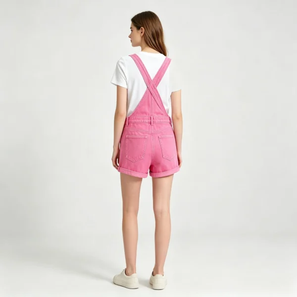 Short women's dungaree overalls denim texture strap buckle and metal hardware macro close-up